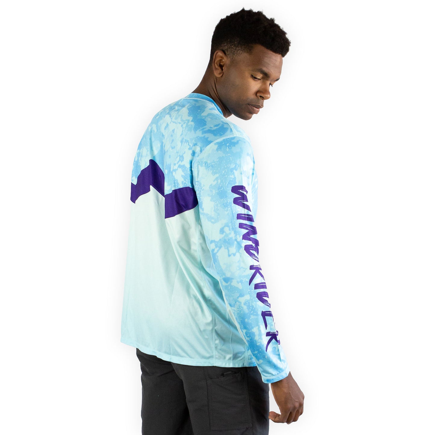 Man in caribbean cove blue sol invictus pro shirt three quarter view studio portrait smiling