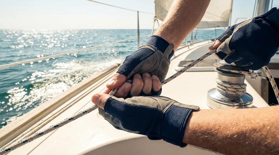 close-up of a sailor's hands gripping and trimming a jib sheet on a sailboat, bright midday glare bouncing off the water behind them