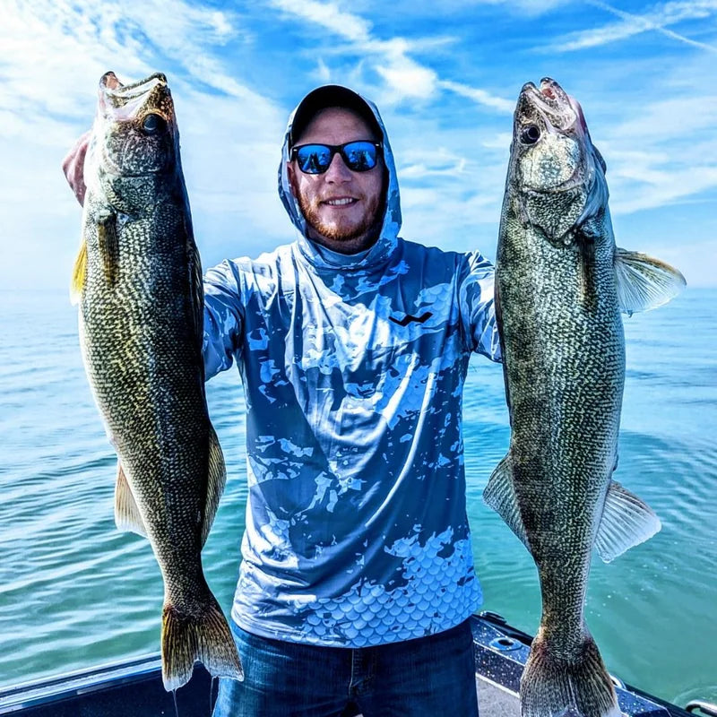 Angler wearing Helios UPF fishing shirt holding walleye on boat