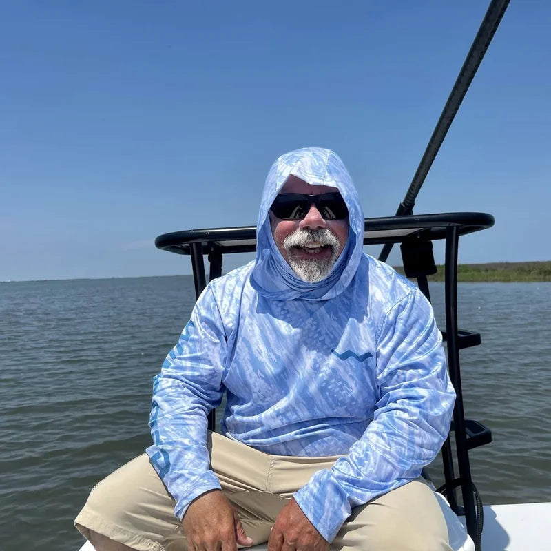 Angler wearing hooded UPF 50+ sun protection shirt with gaiter on boat in bright sunshine