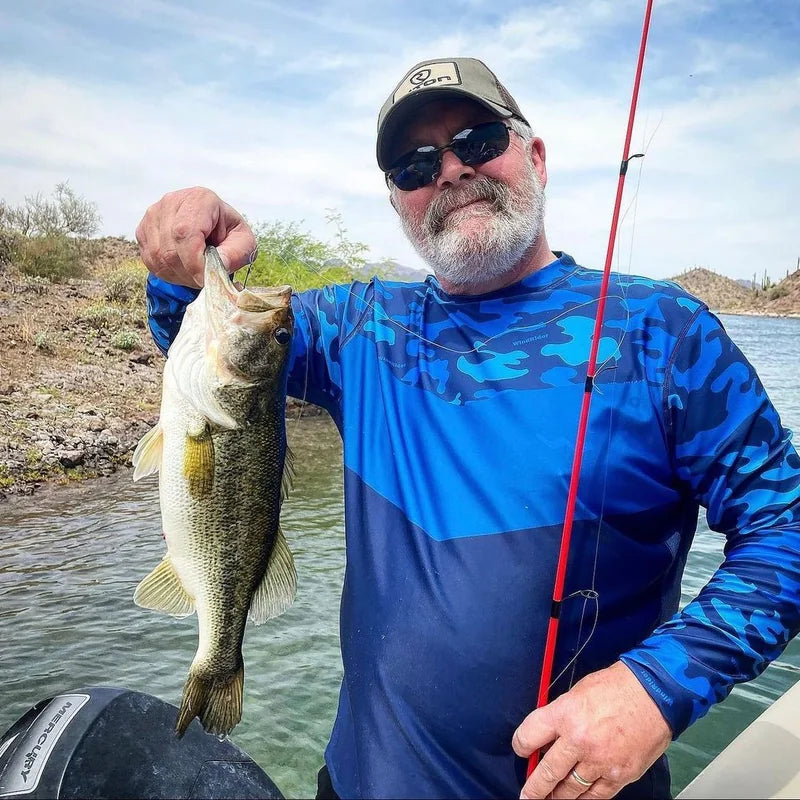 Angler wearing WindRider Helios UPF 50+ sun shirt while fishing on a sunny desert lake