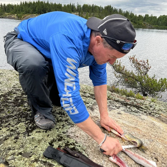 Angler wearing Helios UPF 50+ offshore fishing shirt with tuna catch during trolling expedition, demonstrating professional sun protection