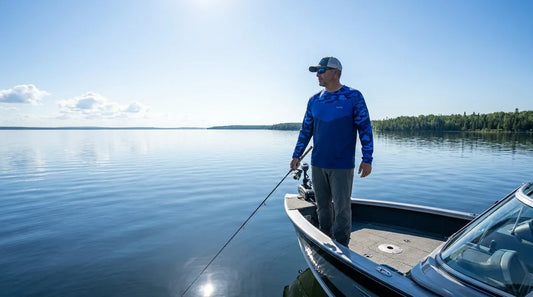angler in long-sleeve fishing shirt standing at the bow of a walleye boat on a large open Minnesota lake, midday sun, flat blue water reflecting light
