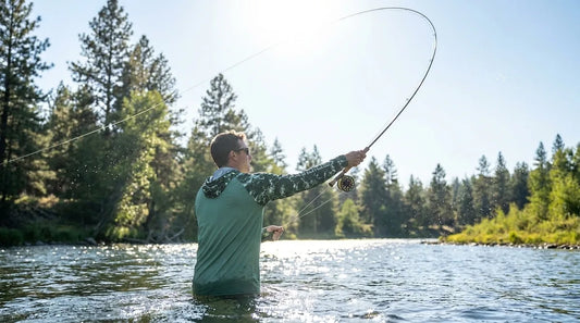 angler mid-overhead fly cast on a sunlit river, fly line arcing against bright sky, glare visible off the water surface, back of the casting hand and forearm clearly lit by direct sun