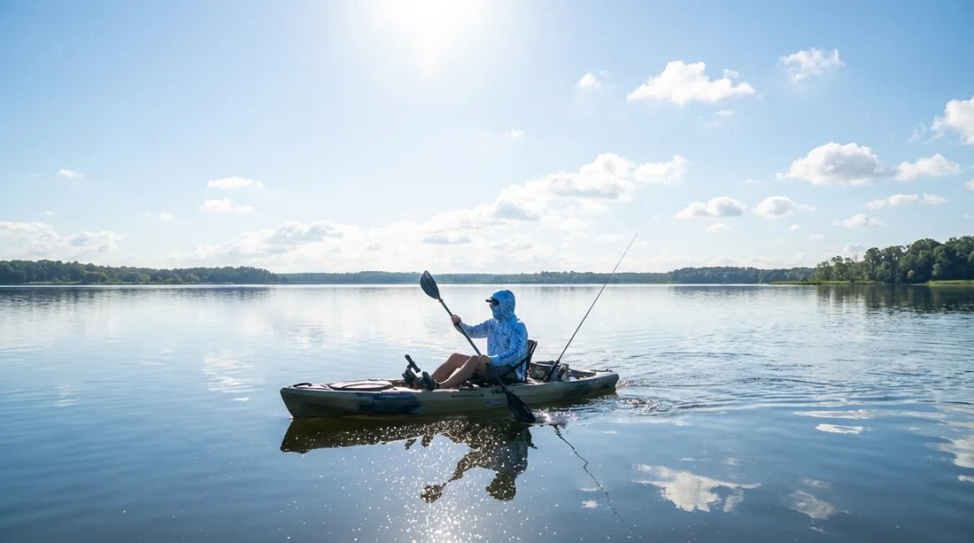 angler in hooded sun shirt paddling a fishing kayak on a calm lake, bright midday sun, water reflection visible, rod secured to kayak