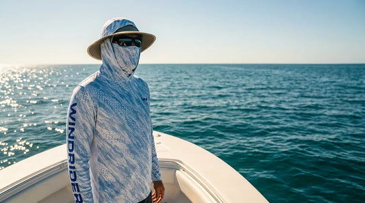 angler on open water boat in bright midday sun, wearing hooded sun shirt with gaiter pulled up, wide-brimmed hat, calm ocean backdrop