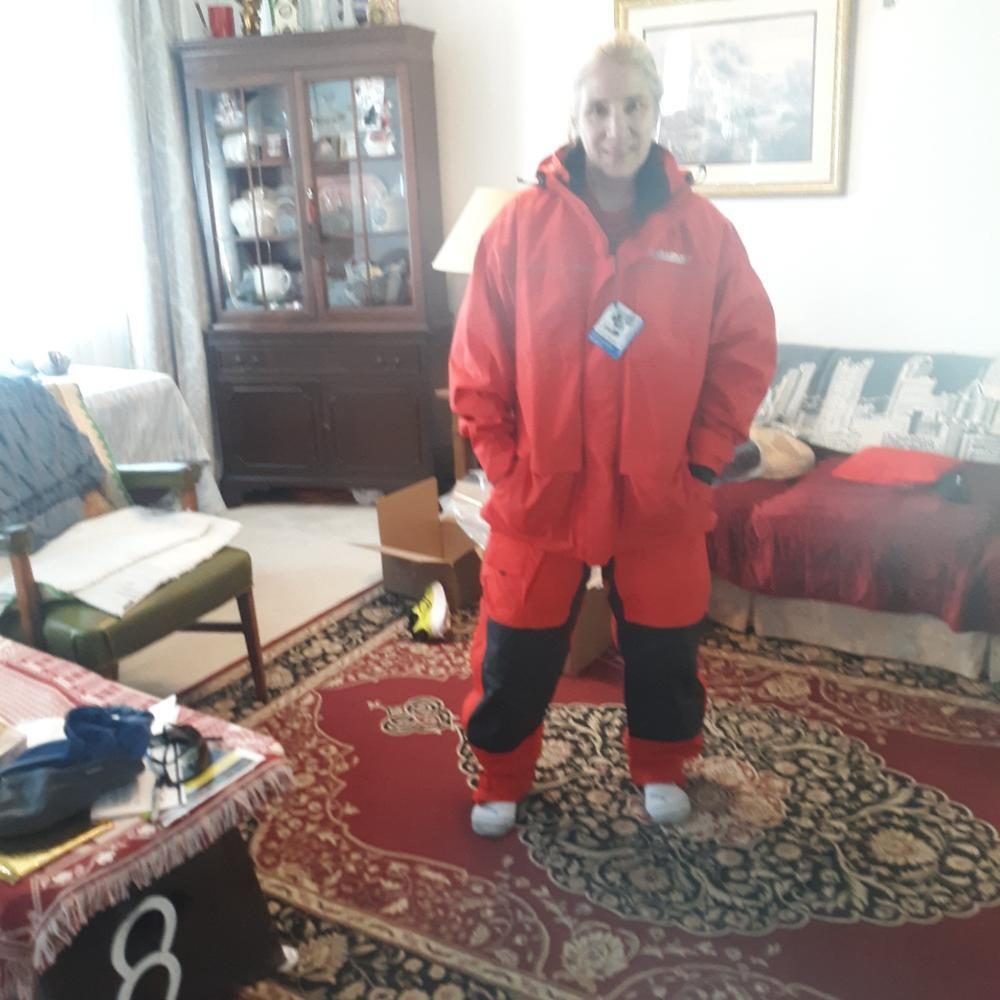 Customer wearing the red Pro All-Weather jacket and bibs before an Alaska trip
