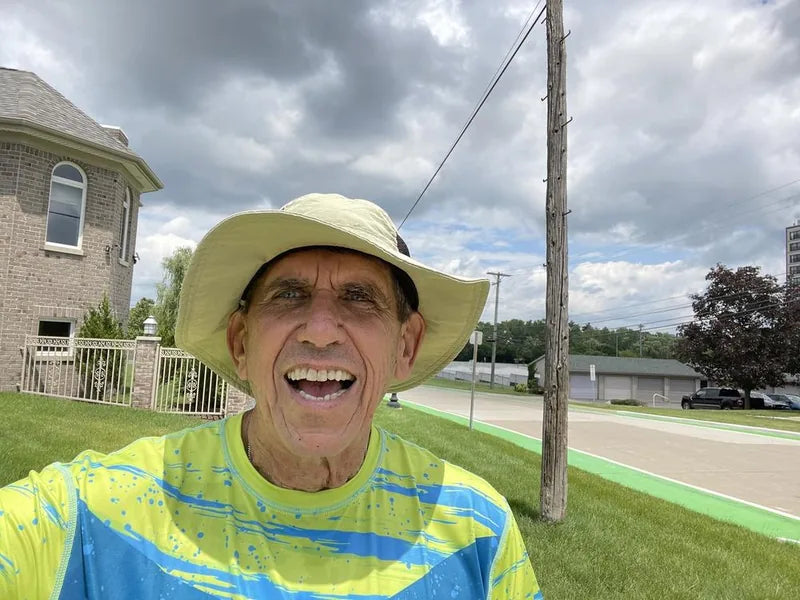 Stanley, a liver transplant recipient and Helios customer, outside in his sun shirt and wide-brim hat.