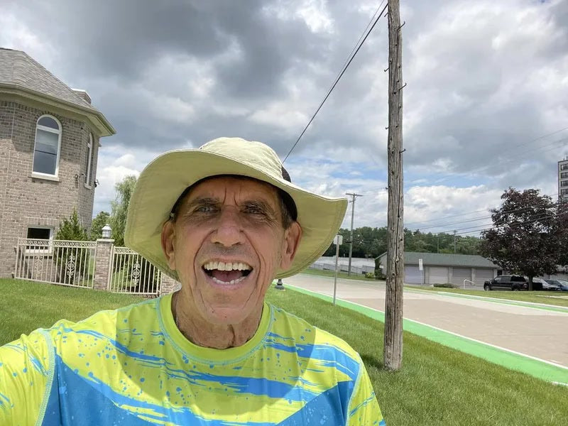 Stanley, a Helios customer, outside in a sun shirt and wide-brim hat.
